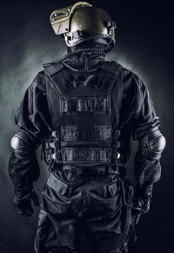 Tactical officer in full black gear, helmet.